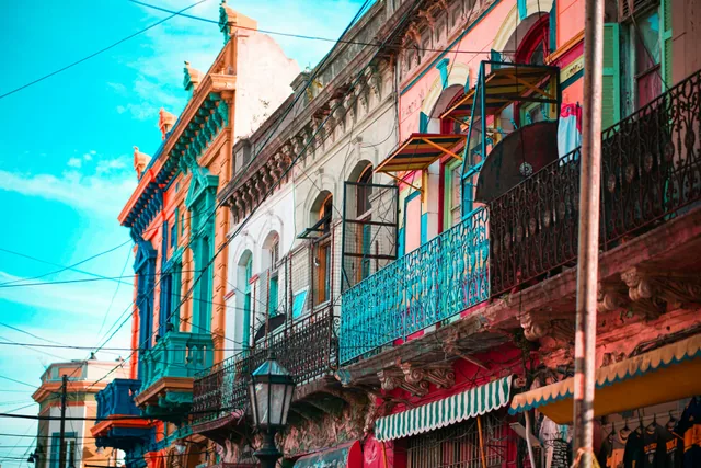 Colourful Buenos Aires facades with painted balconies and street-level awnings.