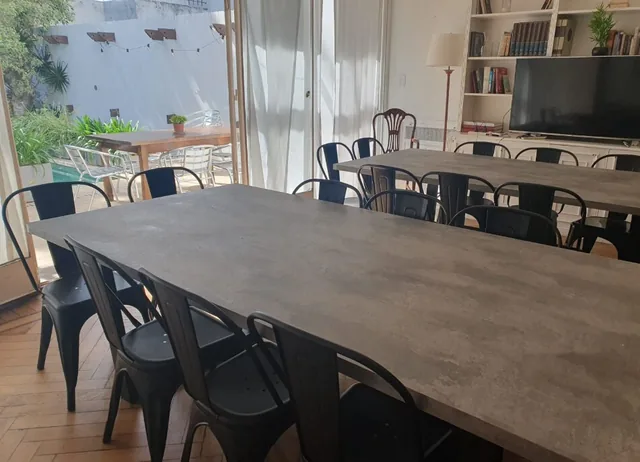 Long dining tables beside glass doors that open onto the pool terrace.