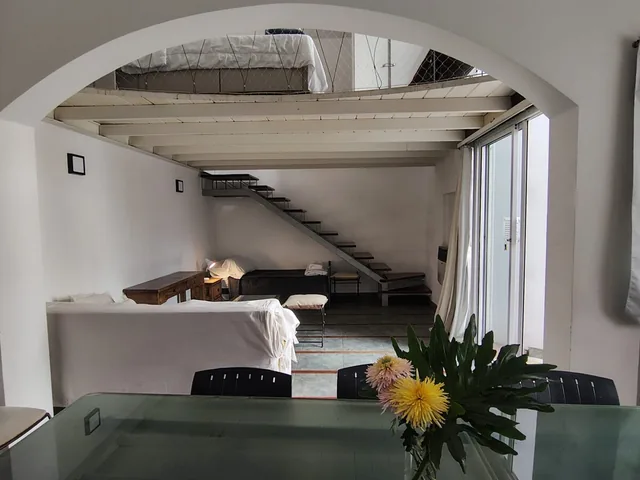 The Garden Loft dining and living area, with stairs leading to the sleeping space.